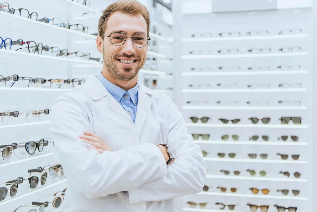 Óptico profesional sonriendo en tienda de gafas
